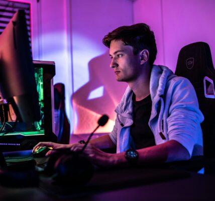 a man sitting behind his PC setup playing the new season of Diablo 4