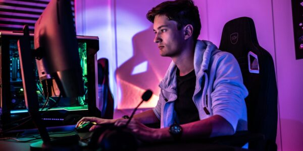 a man sitting behind his PC setup playing the new season of Diablo 4