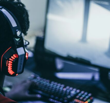 a person wearing headphones playing a S.T.A.L.K.E.R. 2 video game on their PC