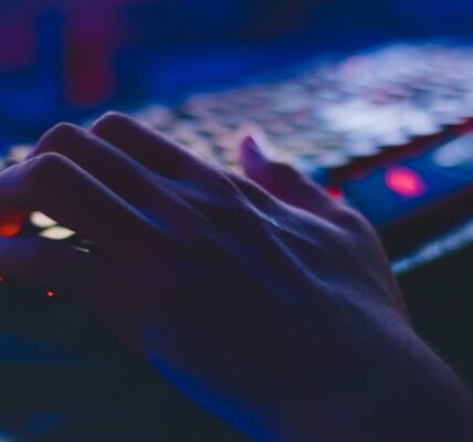 a persons hand on a mechanical keyboard with RGB lighting playing Indiana Jones and The Great Circle