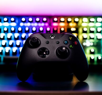 a RGB lit keyboard behind a black X Box controller used to play Assassin's Creed Shadows