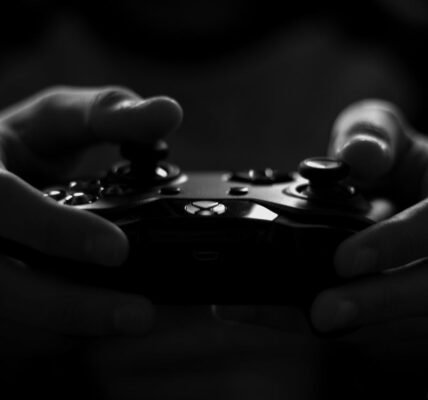 a person holding an X Box controller while playing The First Berserker: Khazan in the dark