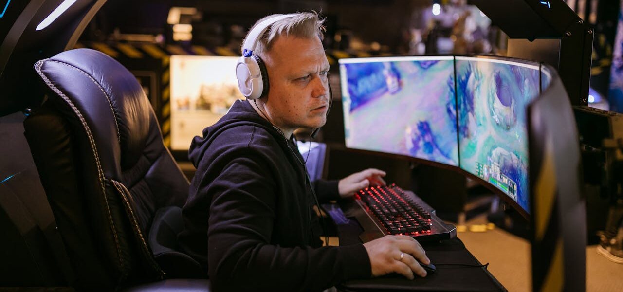 a man playing League of Legends Act 2 on a PC setup with 3 monitors