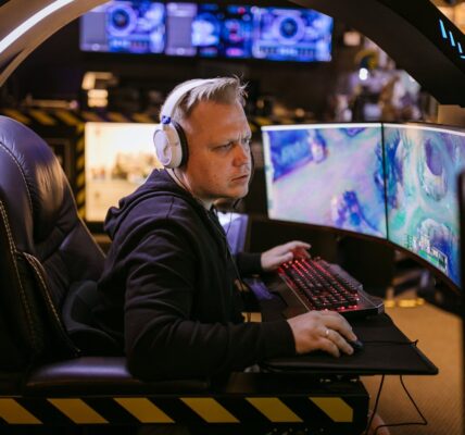 a man playing League of Legends Act 2 on a PC setup with 3 monitors