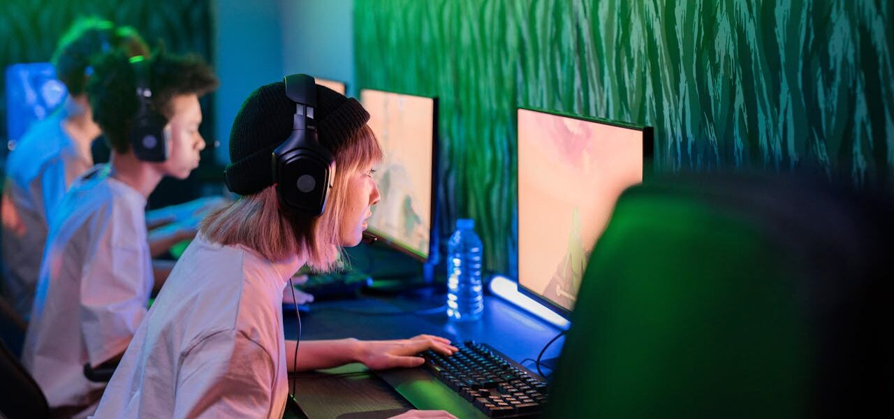 several people sitting in a gaming cafe playing Atomfall