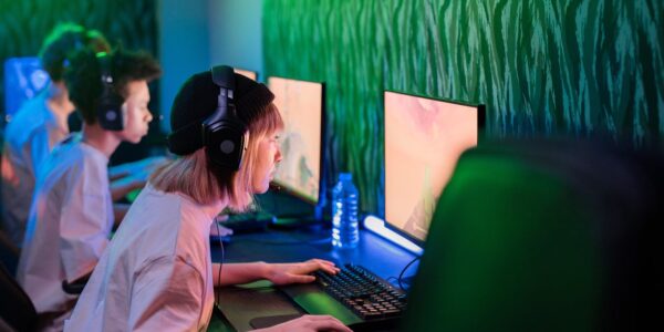 several people sitting in a gaming cafe playing Atomfall