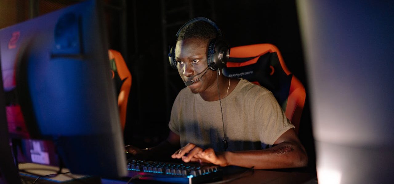 a person sitting in a dark room in front of their PC playing Hell Let Loose