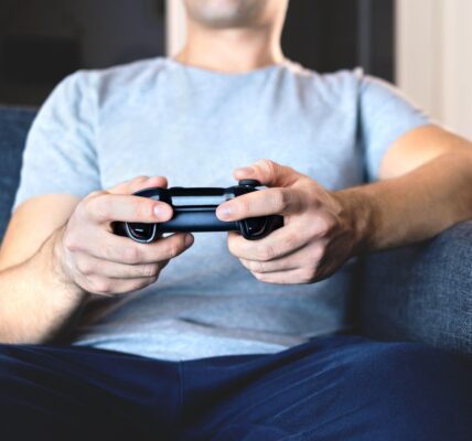 a man in a grey shirt playing Syberia Remastered on his Playstation