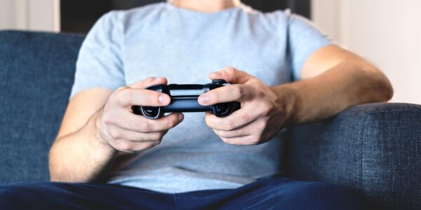 a man in a grey shirt playing Syberia Remastered on his Playstation