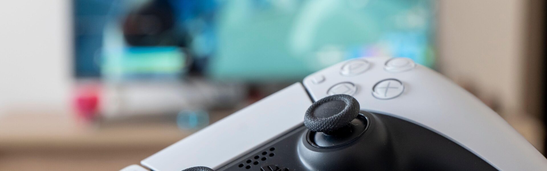 a person holding a white PS 5 controller with a video game on screen to represent the hype for Lost Soul Aside coming in August