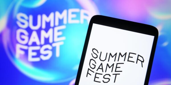 a Summer Game Fest logo on a phone and the wall to represent the day and place Mafia: The Old Country got announced