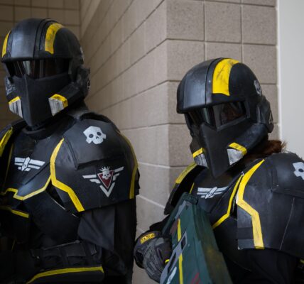 Two Helldivers 2 video game cosplayers in full armor suits