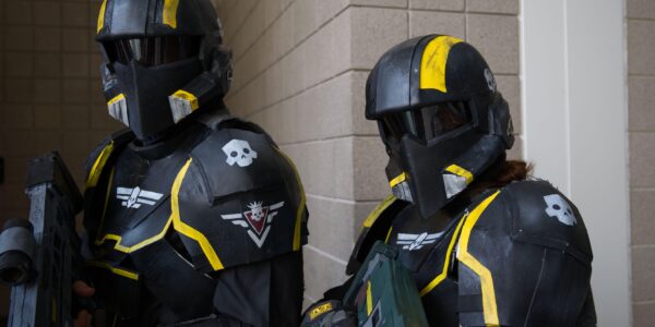 Two Helldivers 2 video game cosplayers in full armor suits