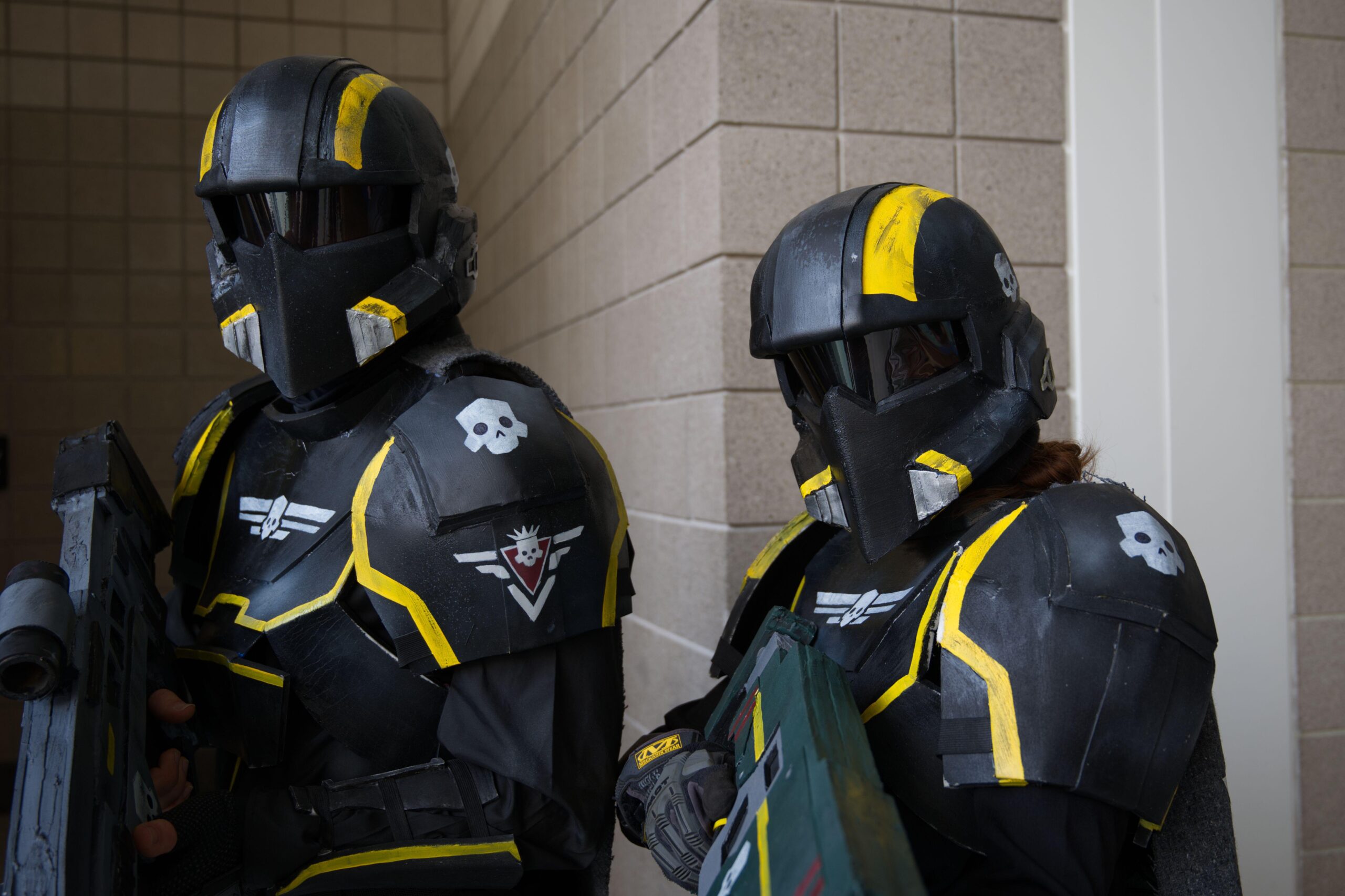 Two Helldivers 2 video game cosplayers in full armor suits