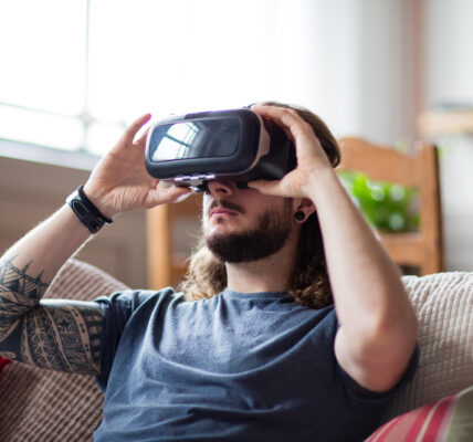 a man sitting on a couch in his home playing Chrono Weavers on his VR