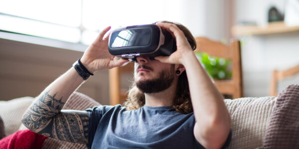 a man sitting on a couch in his home playing Chrono Weavers on his VR